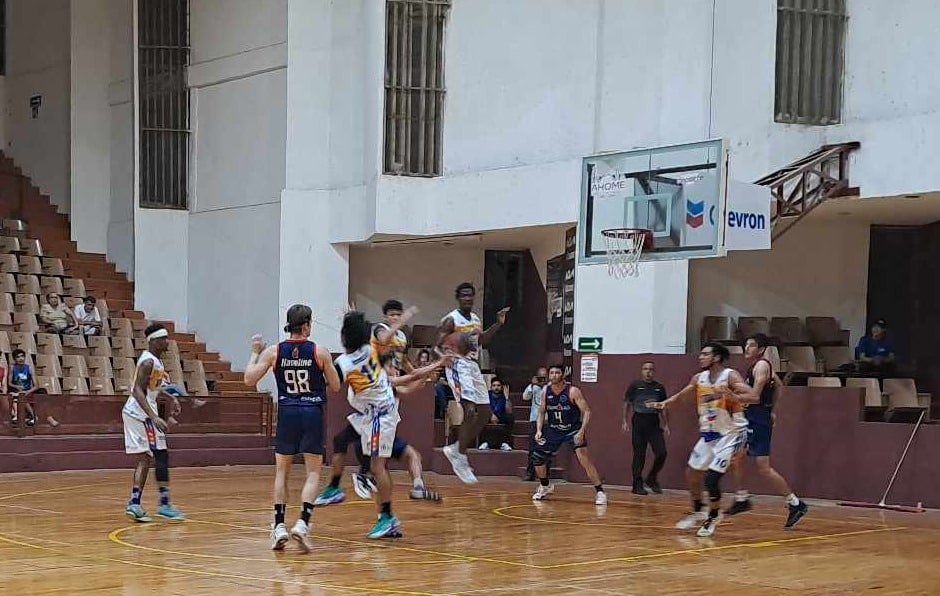 Personas con uniforme de basquetbol jugando