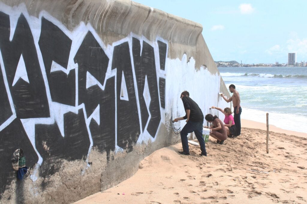 Tras grafitear una barda en playa de Mazatlán, cuatro jóvenes de Culiacán reparan el daño