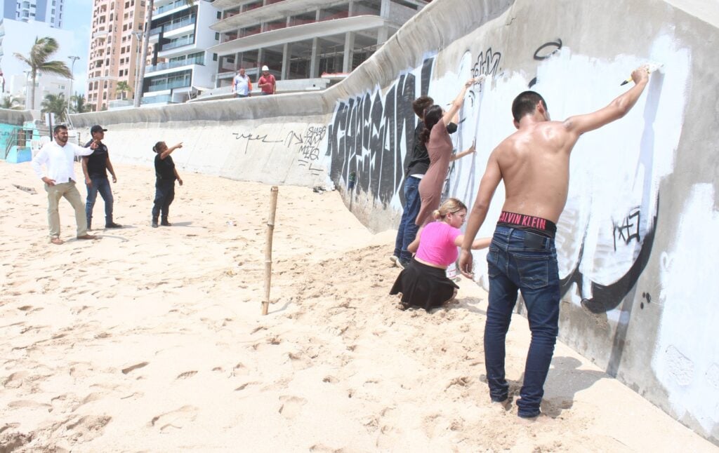 Tras grafitear una barda en playa de Mazatlán, cuatro jóvenes de Culiacán reparan el daño