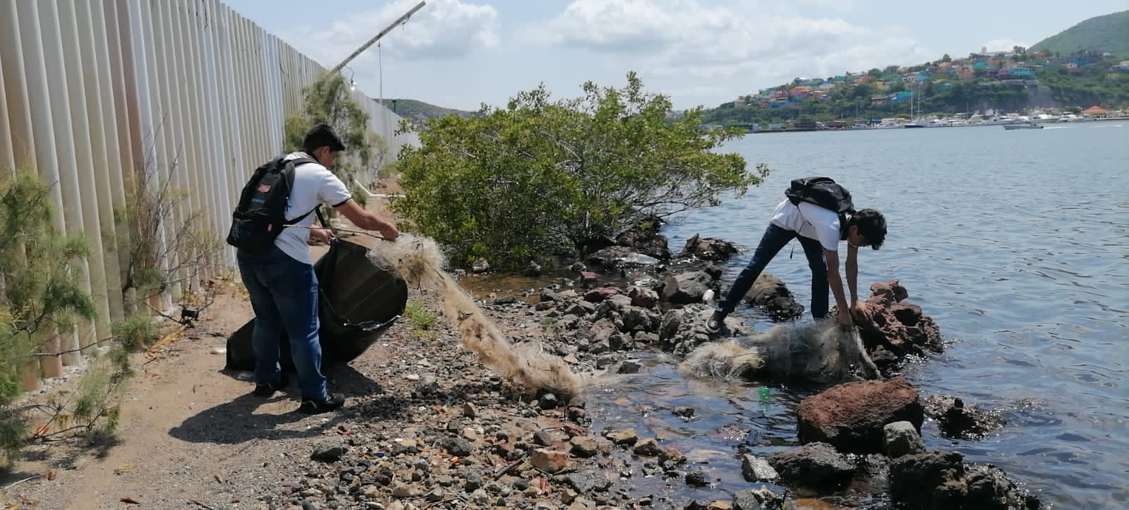 Jóvenes limpiando la orilla del mar