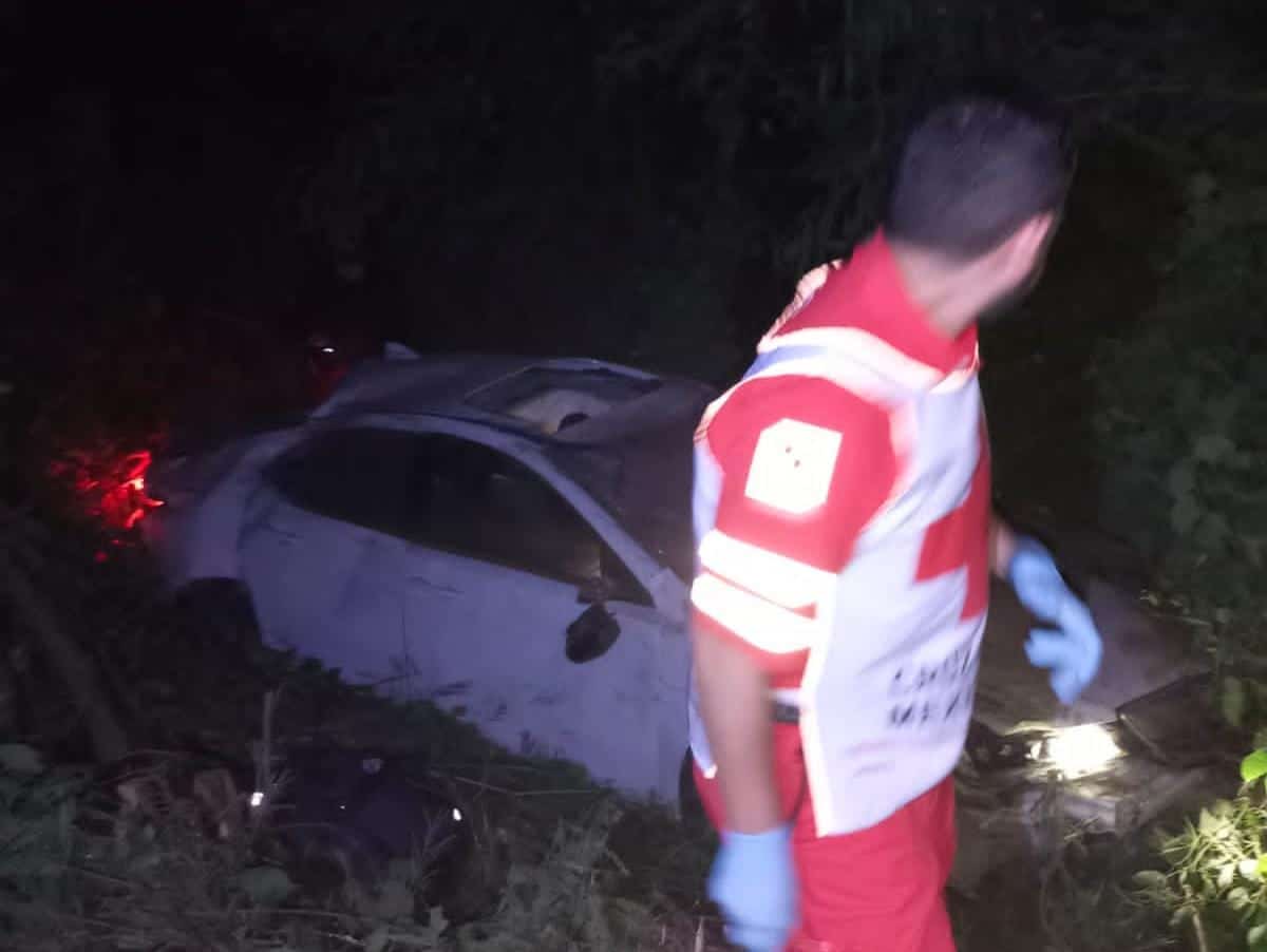Socorrista revisando automóvil accidentado abandonado