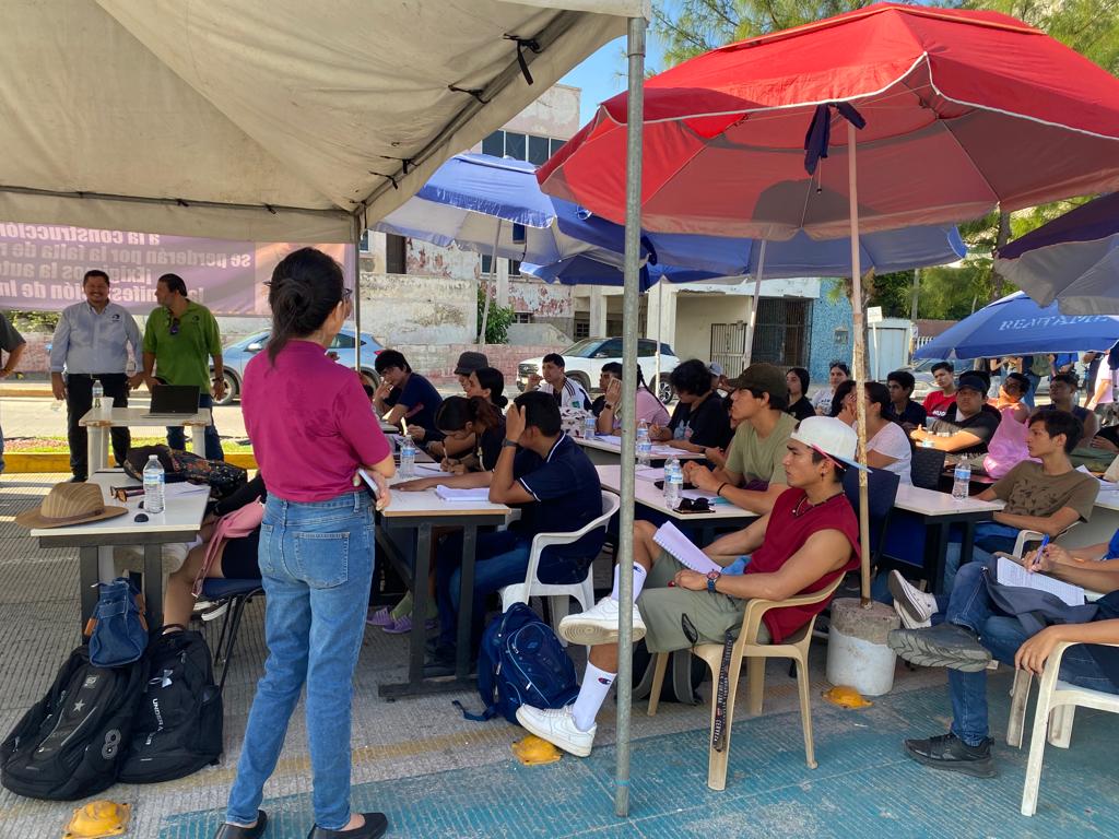 Alumnos tomando clases a las afueras del plantel.