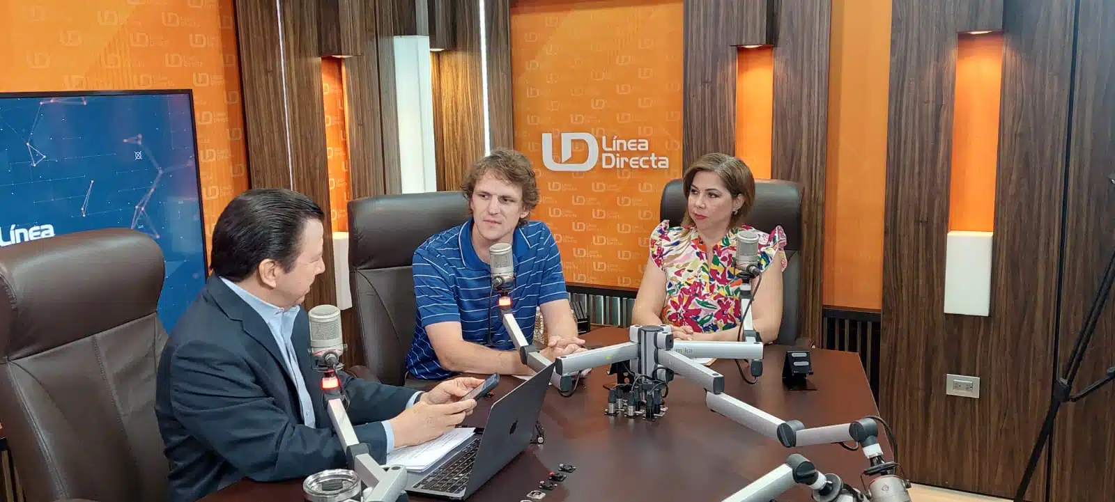 3 personas sentadas en un estudio de radio