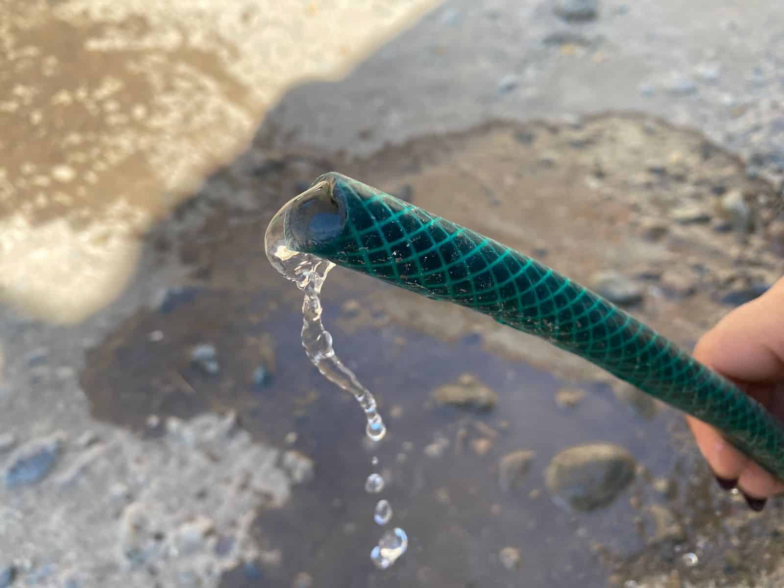 Chorrito de agua saliendo de una manguera