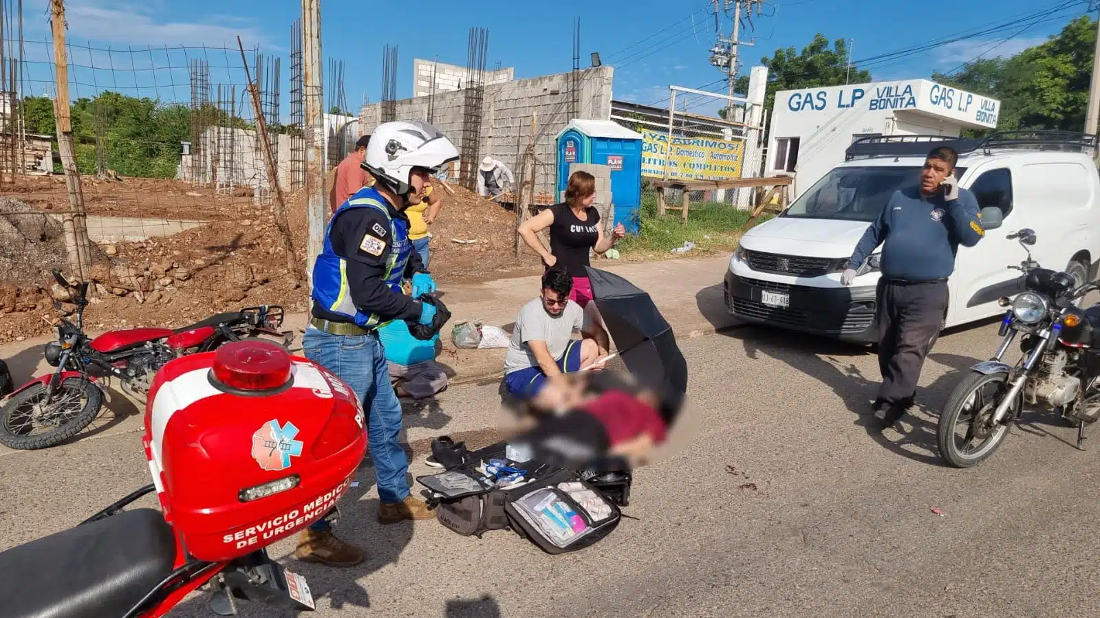 Mujer en el suelo recibiendo atención tras accidente