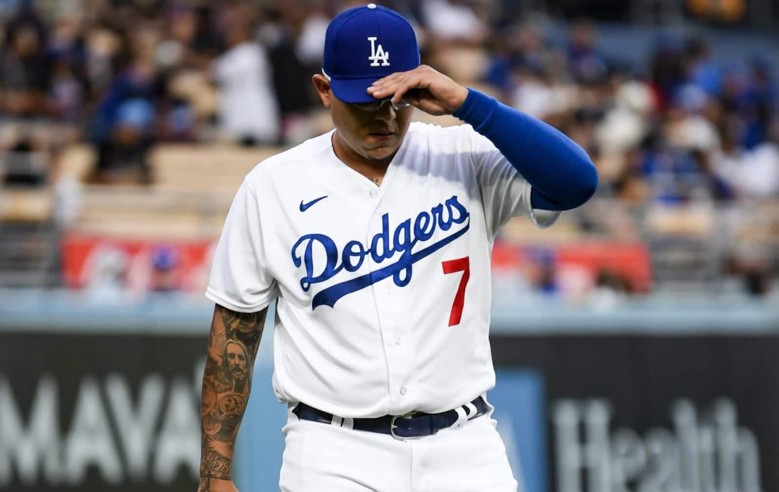 Julio Urías ajustando su gorra en el campo
