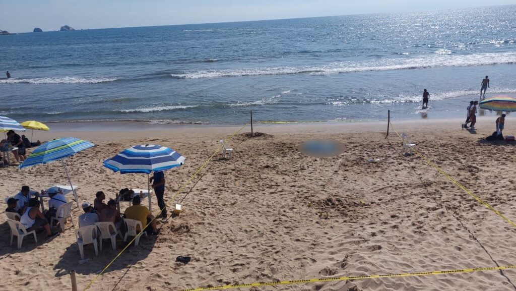 Área rodeada de cinta amrilla donde se encuentra cuerpo de hombre en la playa