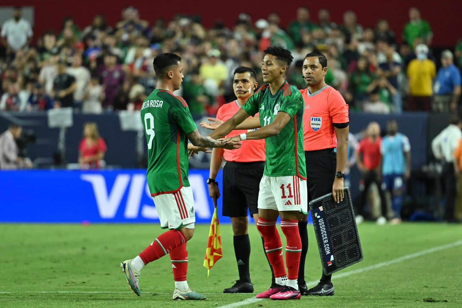 Dos jugadores del Tri haciendo el cambio en la cancha