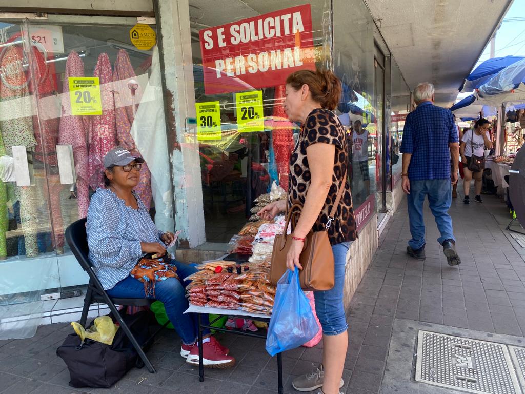 María atendiendo a una clienta en su puesto