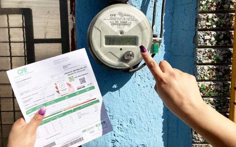 mano sostenienod recibo de CFE y señalando medidor