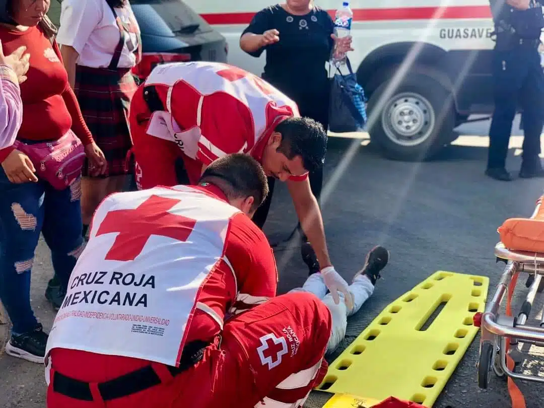 Paramédicos de la Cruz Roja Mexicana agachados con lesionado en el sueño