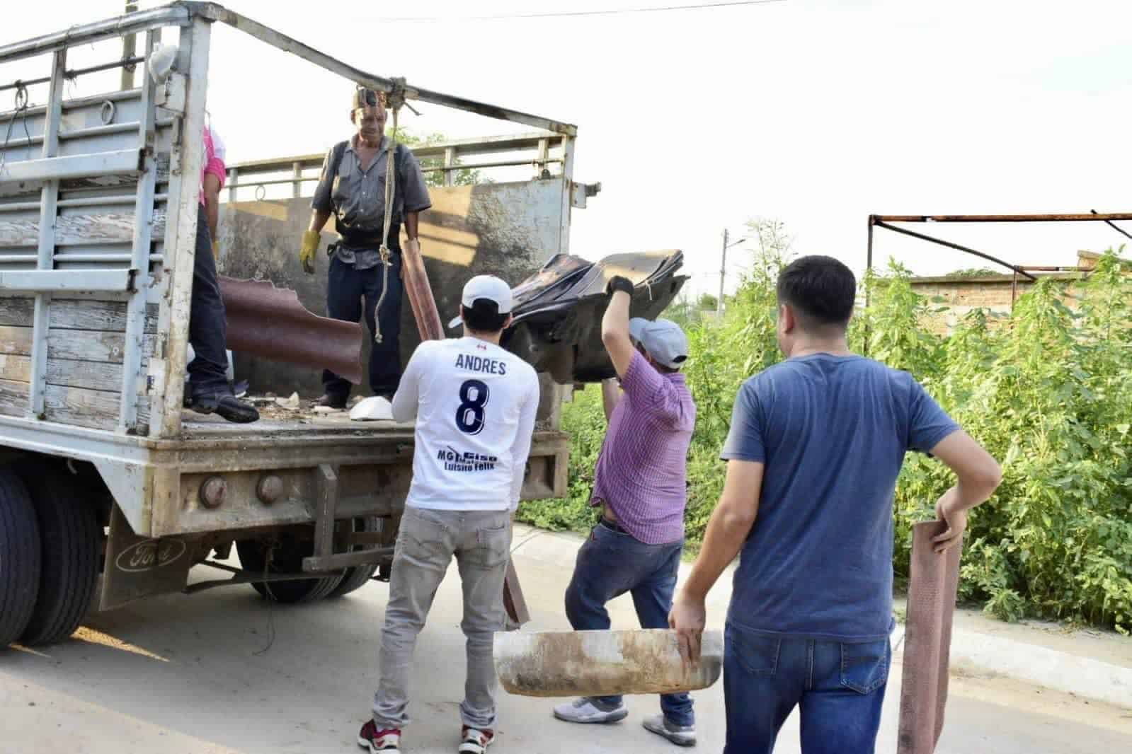 personas subiendo a camioneta chatarra
