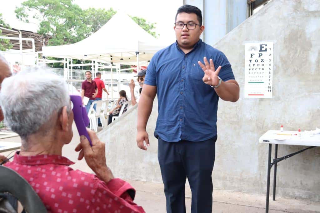 Adulta mayor realizando prueba óptica con personal especializado