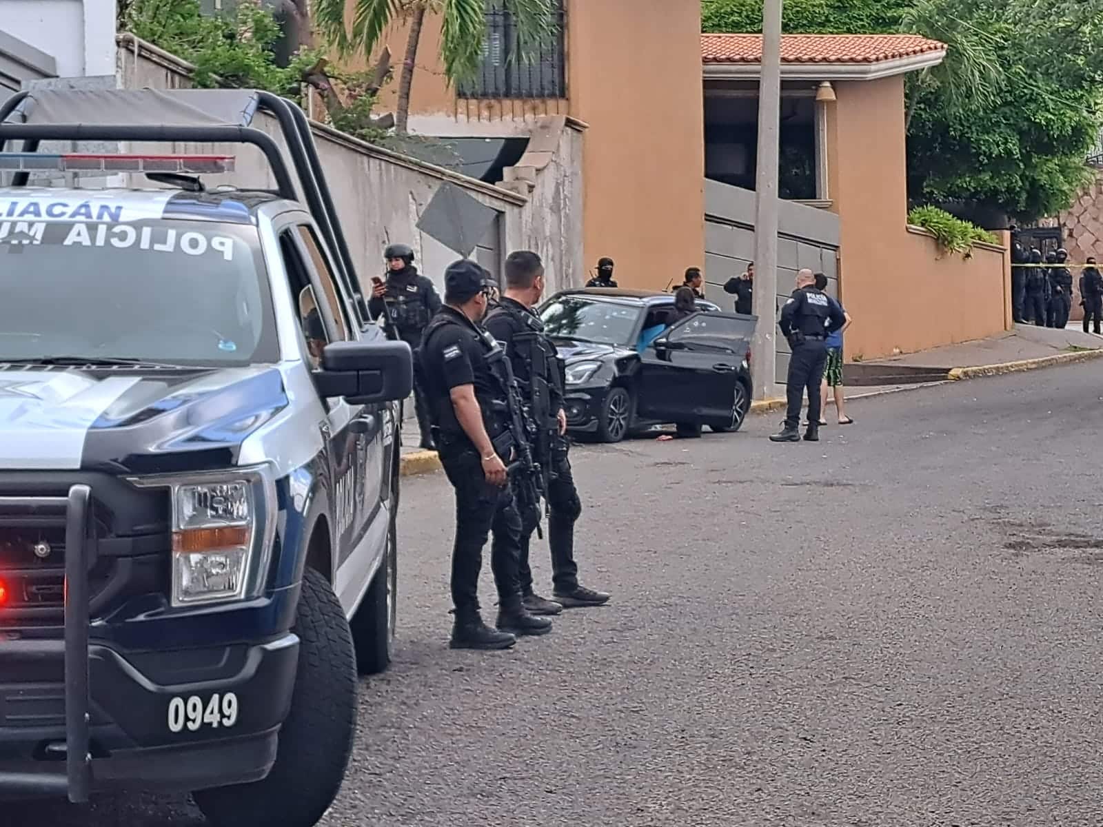 ELMENTOS DE LA POLICIA ESTATAL Y A LO LEJOS EL CARRO DE LA PERSONA ASESINADA.
