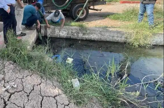 Personas tomando muestras de agua en canal