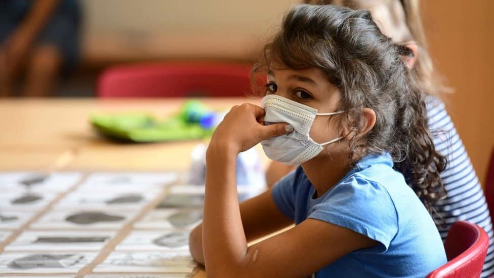 Niña con cubrebocas en escuela