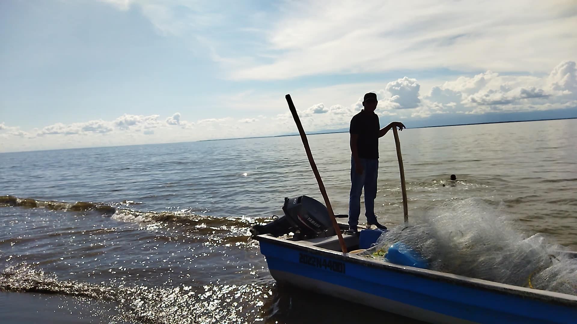 Pescador soibre lancha en la orilla del mar