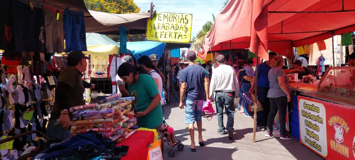 Personas vendiendo y comprando en tianguis