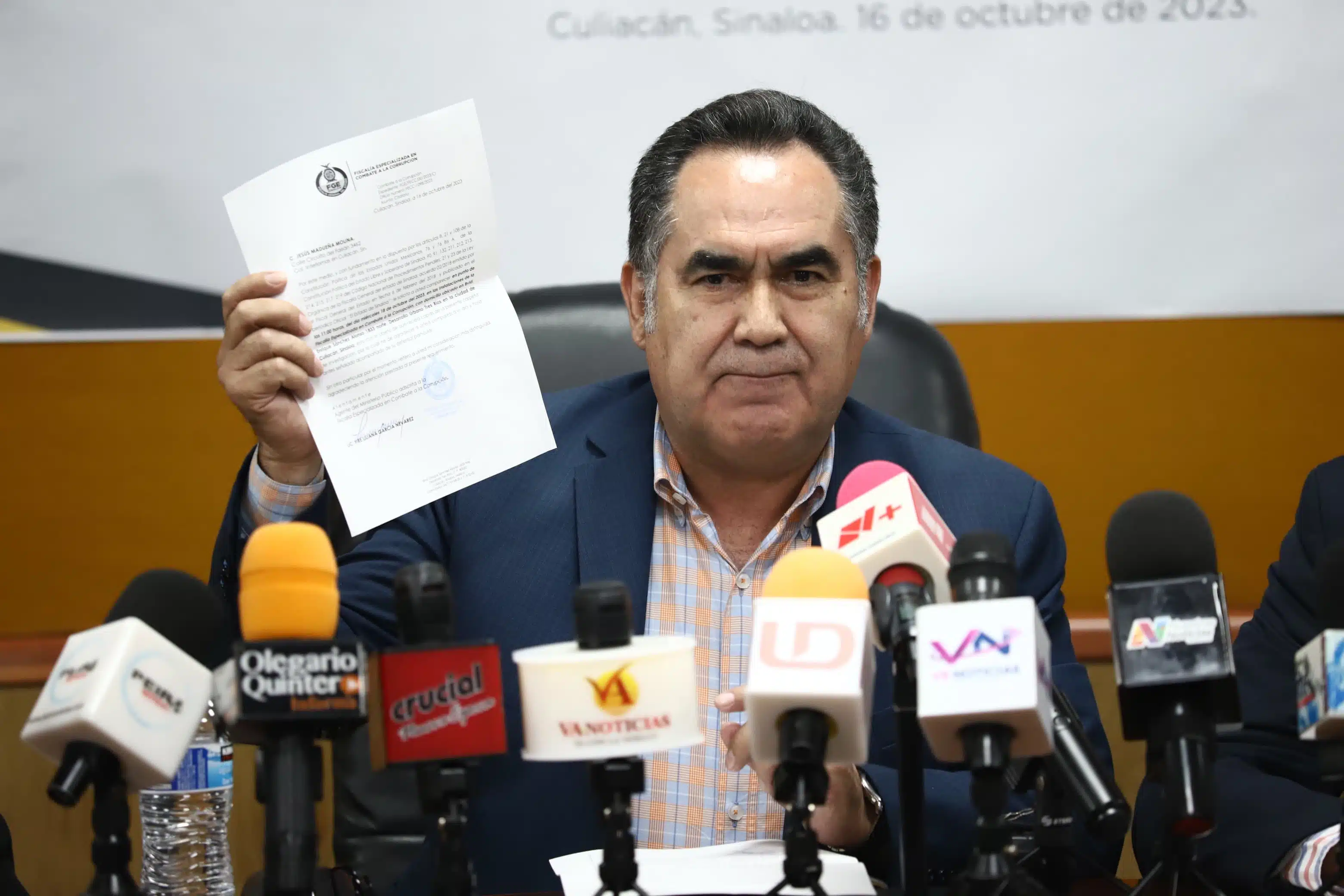 Jesús Madueña Molina sosteniendo la nueva cita por parte de la Fiscalía