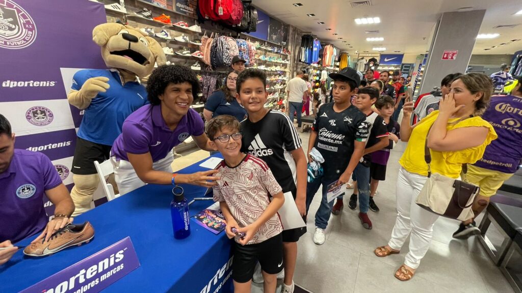 Niños aficionados tomándose una foto con un jugador de Mazatlán FC