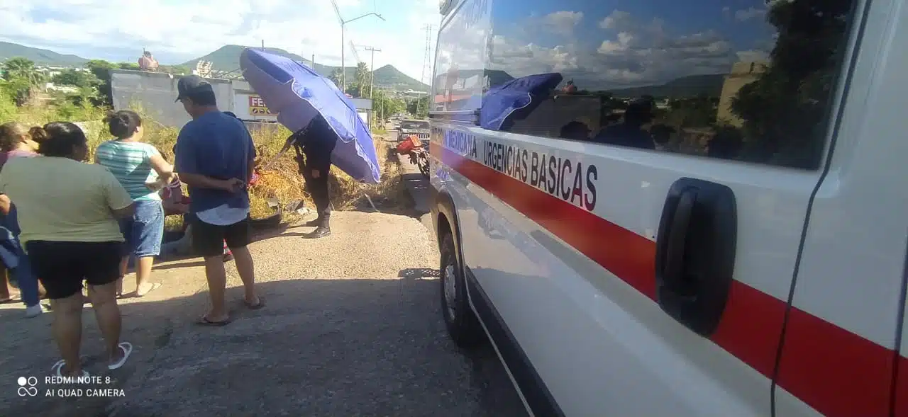 Ambulancia de la Cruz Roja y testigos en el lugar donde cayó el motociclista que convulsionó