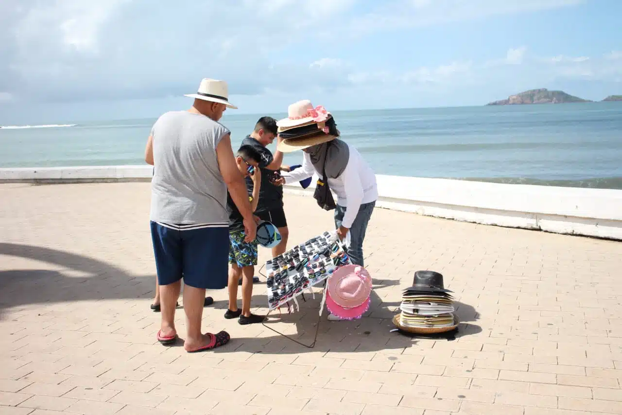 Clientes comprando a vendedor ambulante en playa mazatleca