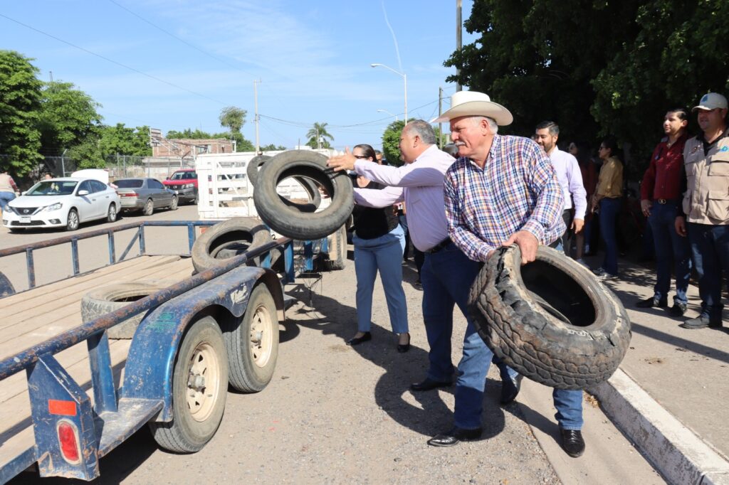 Alcalde Rolando Mercando lanzando una llanta hacia el remolque