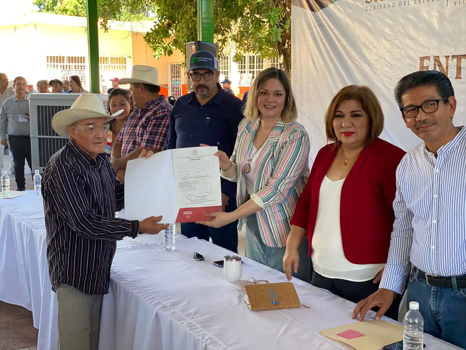 Alcalde de Guasave y la titular de Sebides entregando el título de propiedad a un beneficiario