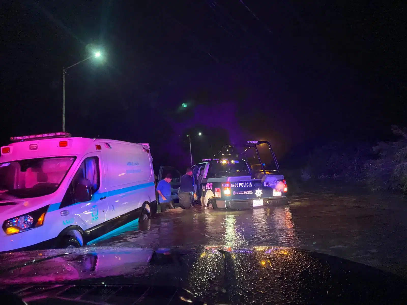 Policía Municipal ayudando a una ambulancia varada por las lluvias