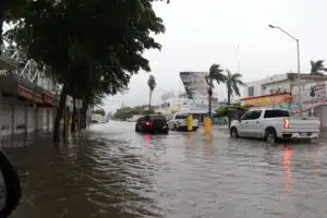 Autos parados tras lluvias e inundación por la calle Independencia sector Centro Los Mochis por ciclón Norma