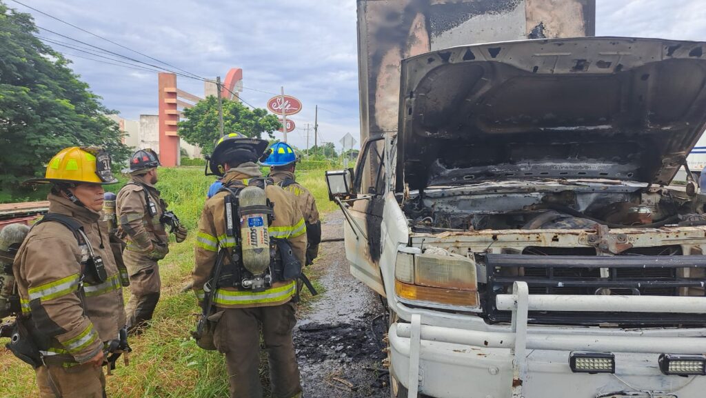 Bomberos a un lado de la camioneta siniestrada por el fuego en Mazatlán