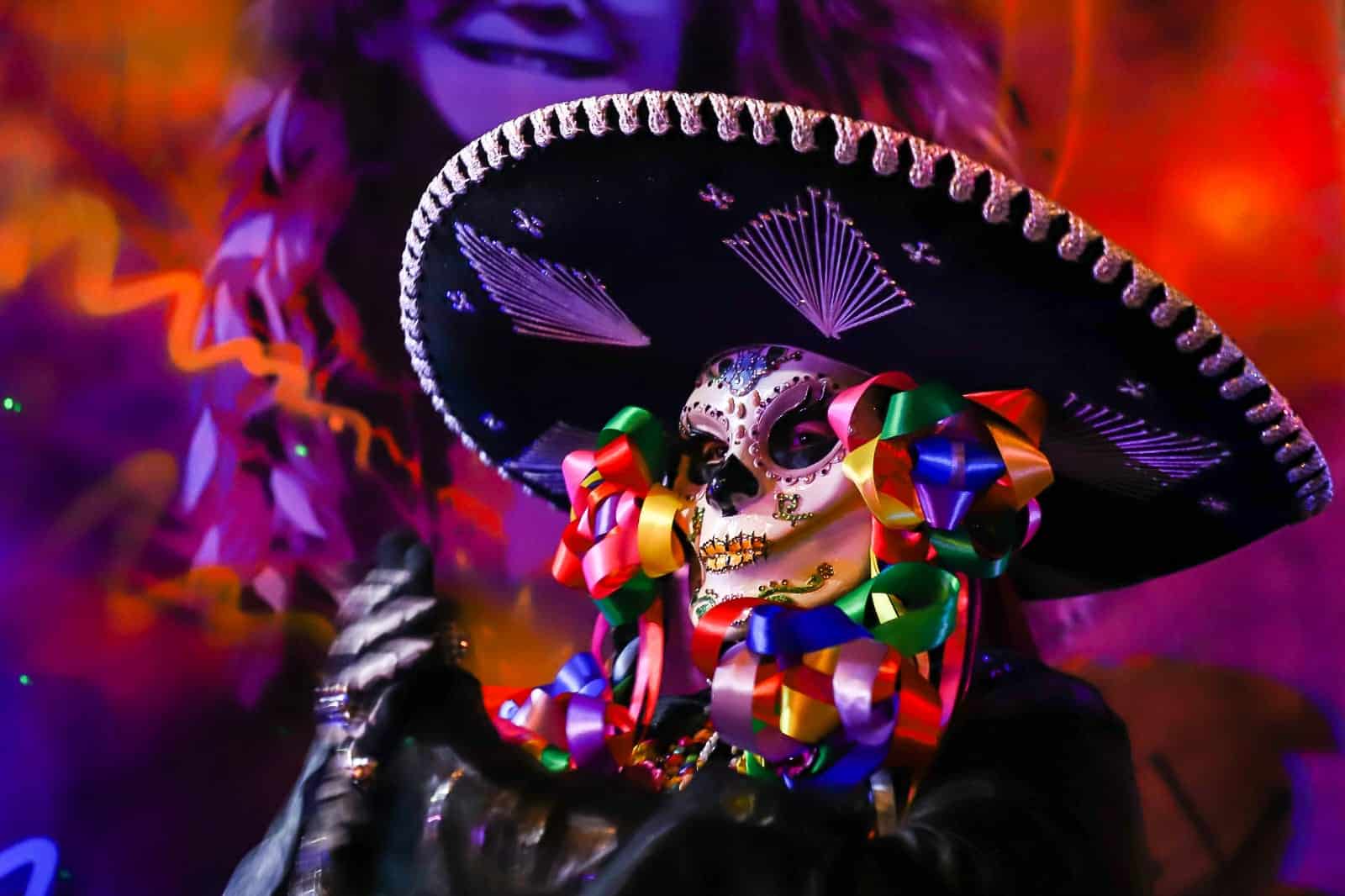 Vestidos de catrinas y catrines marchan al son de una batucada.