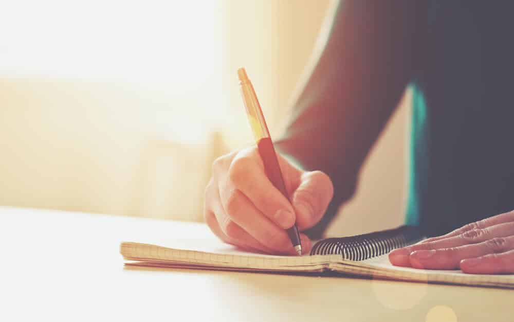 Persona escribiendo en una libreta