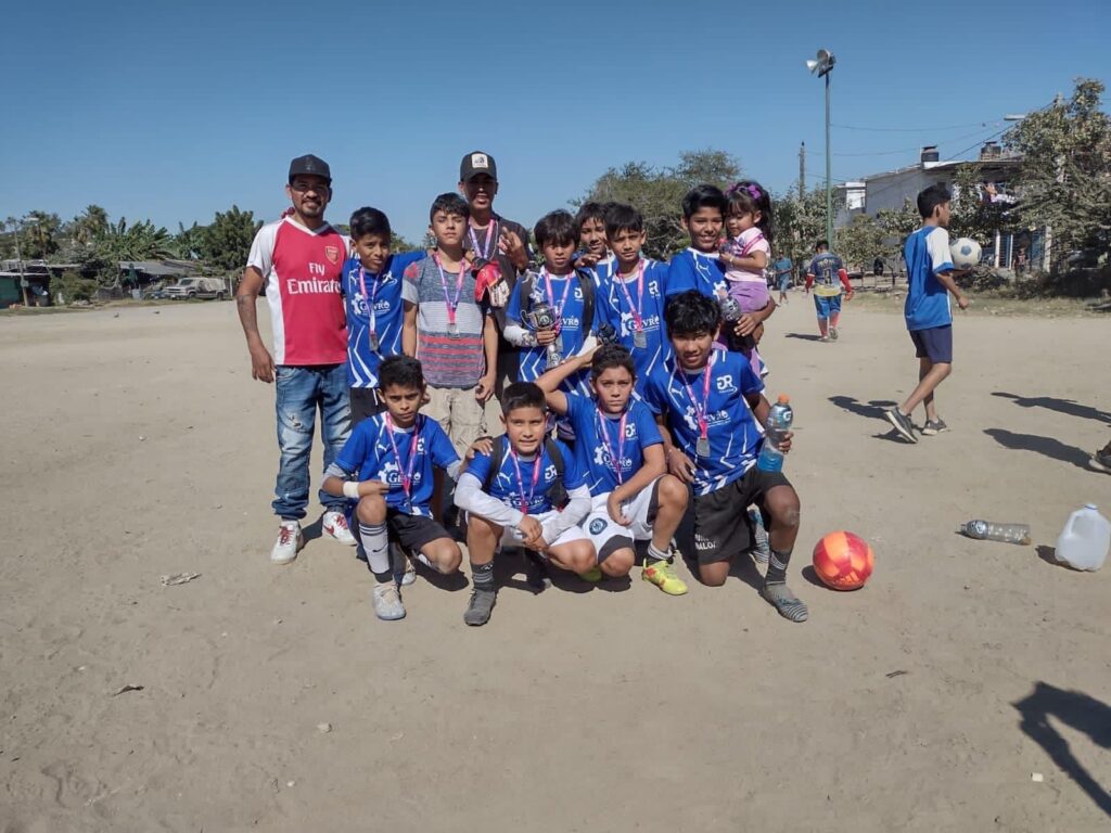 Niños en una cancha de futbol de Mazatlán formados para tomarse una foto