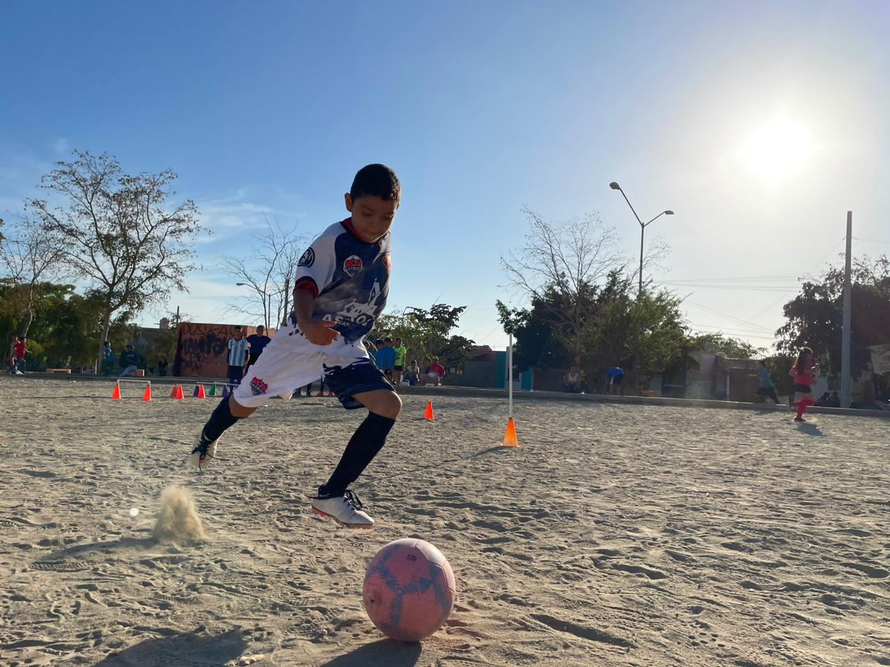 Un niño jugando en una cancha de futbol en Mazatlán