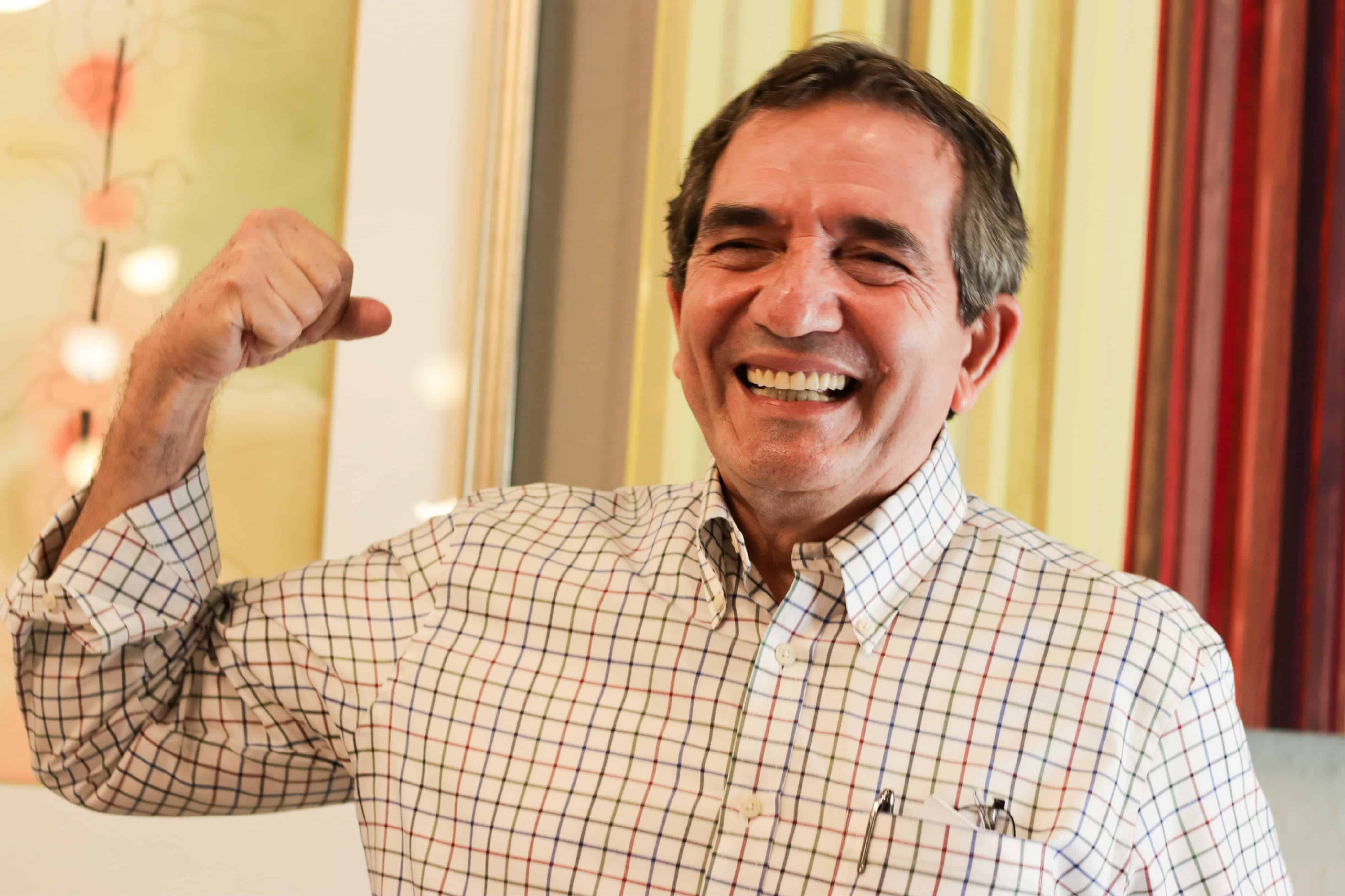 Melesio Cuen sonriendo con brazo levantado