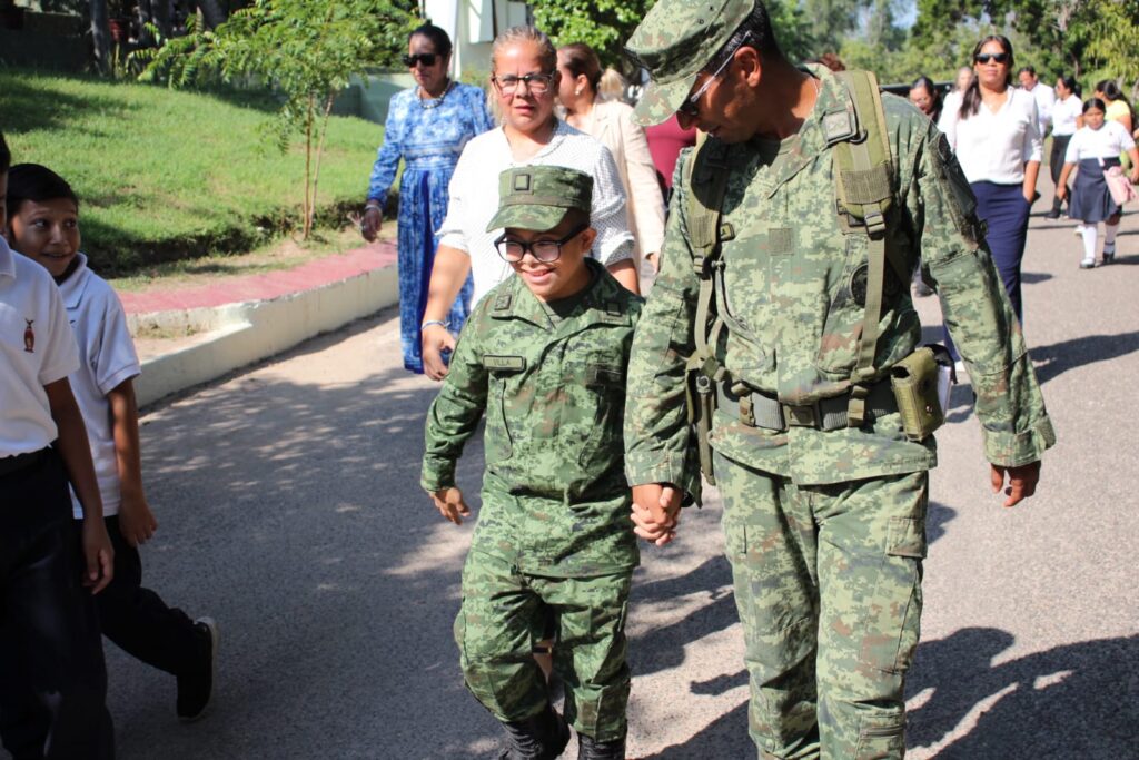 Julio Martín caminando junto a militar.