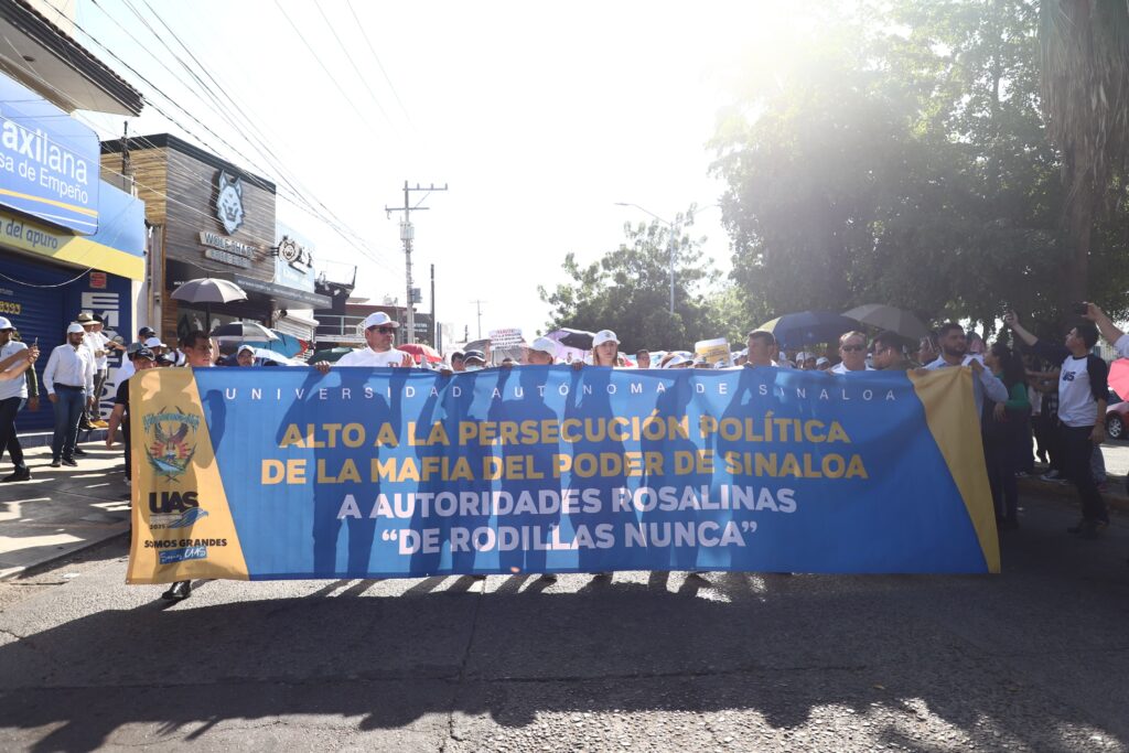 Estudiantes y maestros de la UAS con una pancarta enfrente marchando en Culiacán 