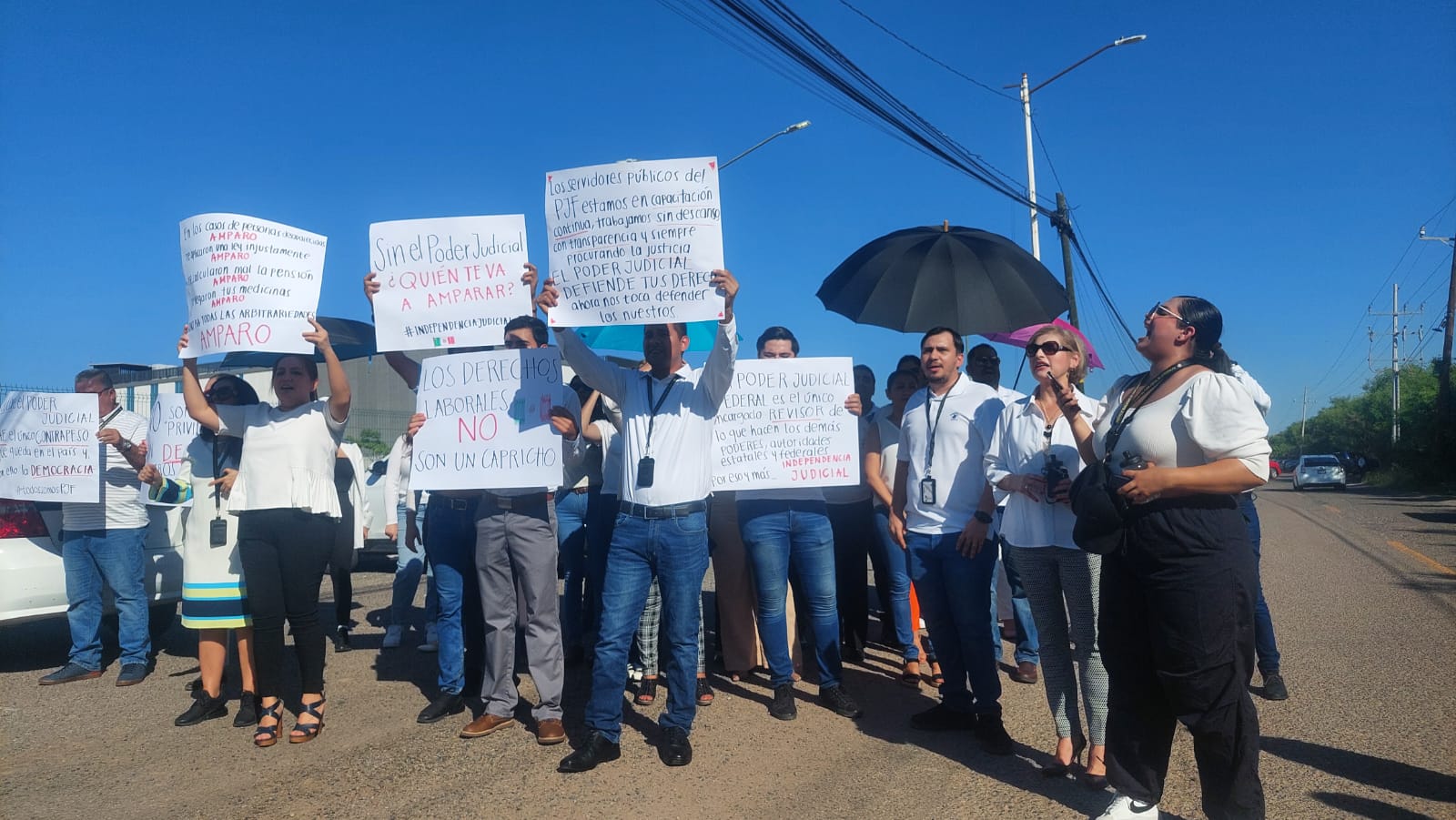 Personas manifestándose con cartulinas en Culiacán