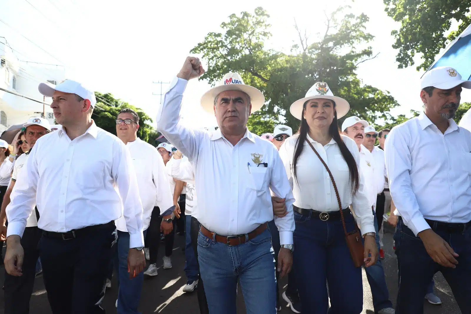 Jesús Madueña con el puño arriba mientras marcha acompañado de funcionarios de la UAS y demás comunidad universitaria