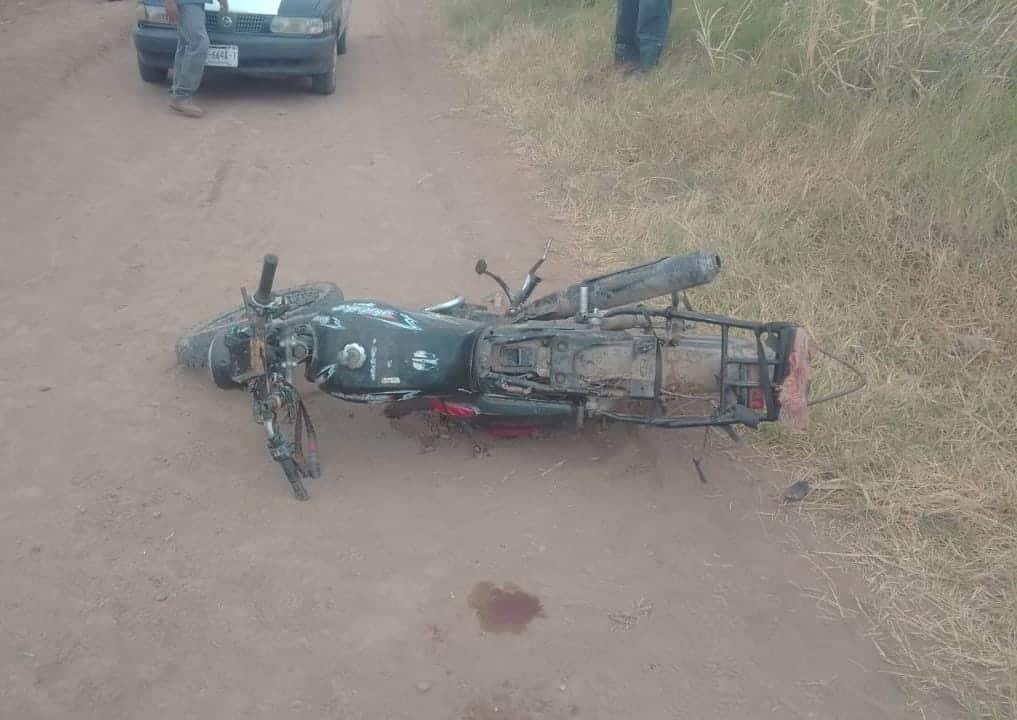 motocicleta Italika, color negro tirada en el suelo tras accidente vial