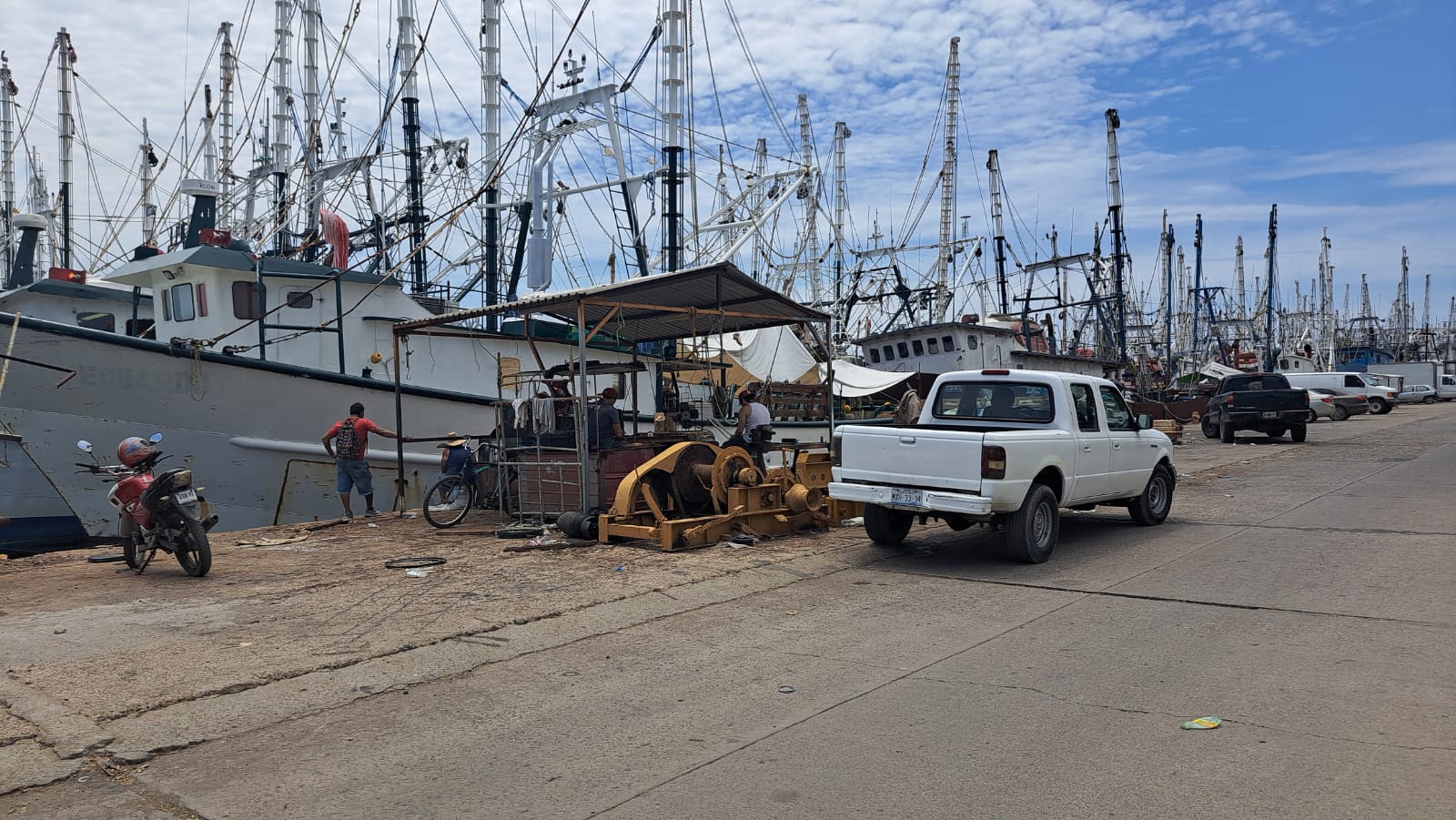 Pescadores realizan trabajo de pesca en muelle del parque industrial Alfredo V. Bonfil.