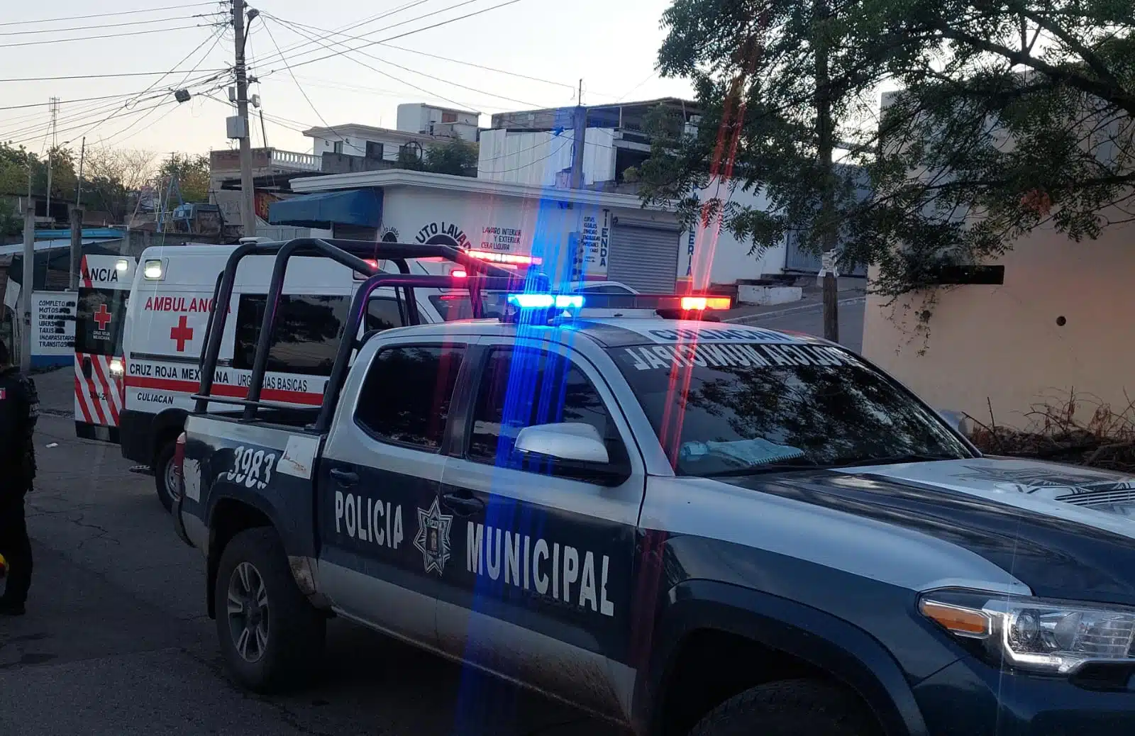 2 camionetas una de la policía municipal y la otra de la Cruz Roja con las puestas traseras abiertas