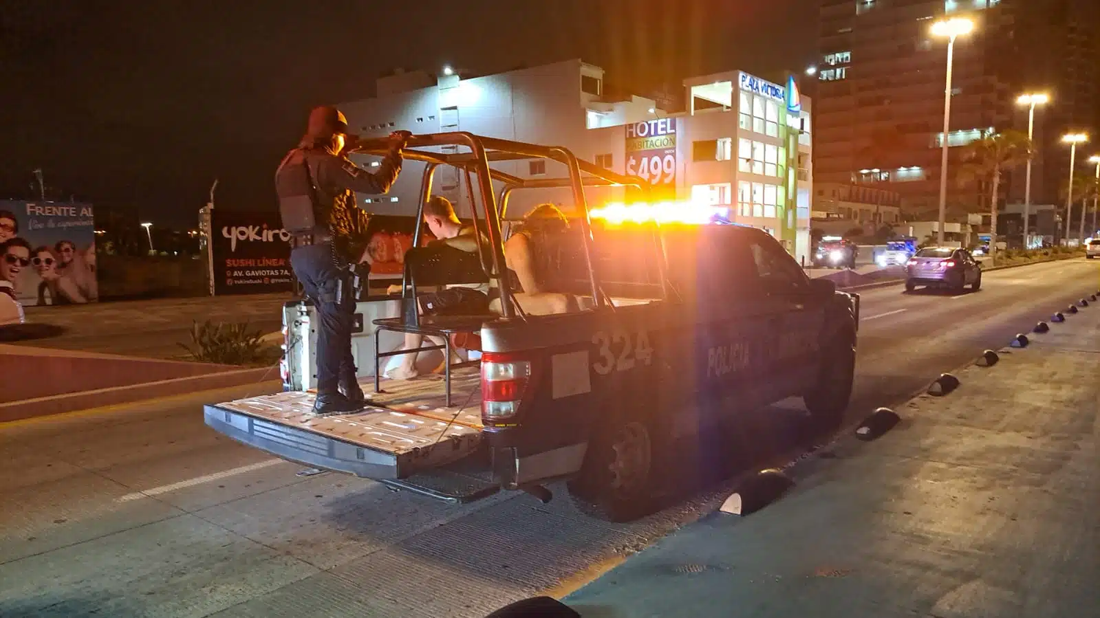 Camioneta de la policía Municipal de Mazatlán con 3 personas arriba