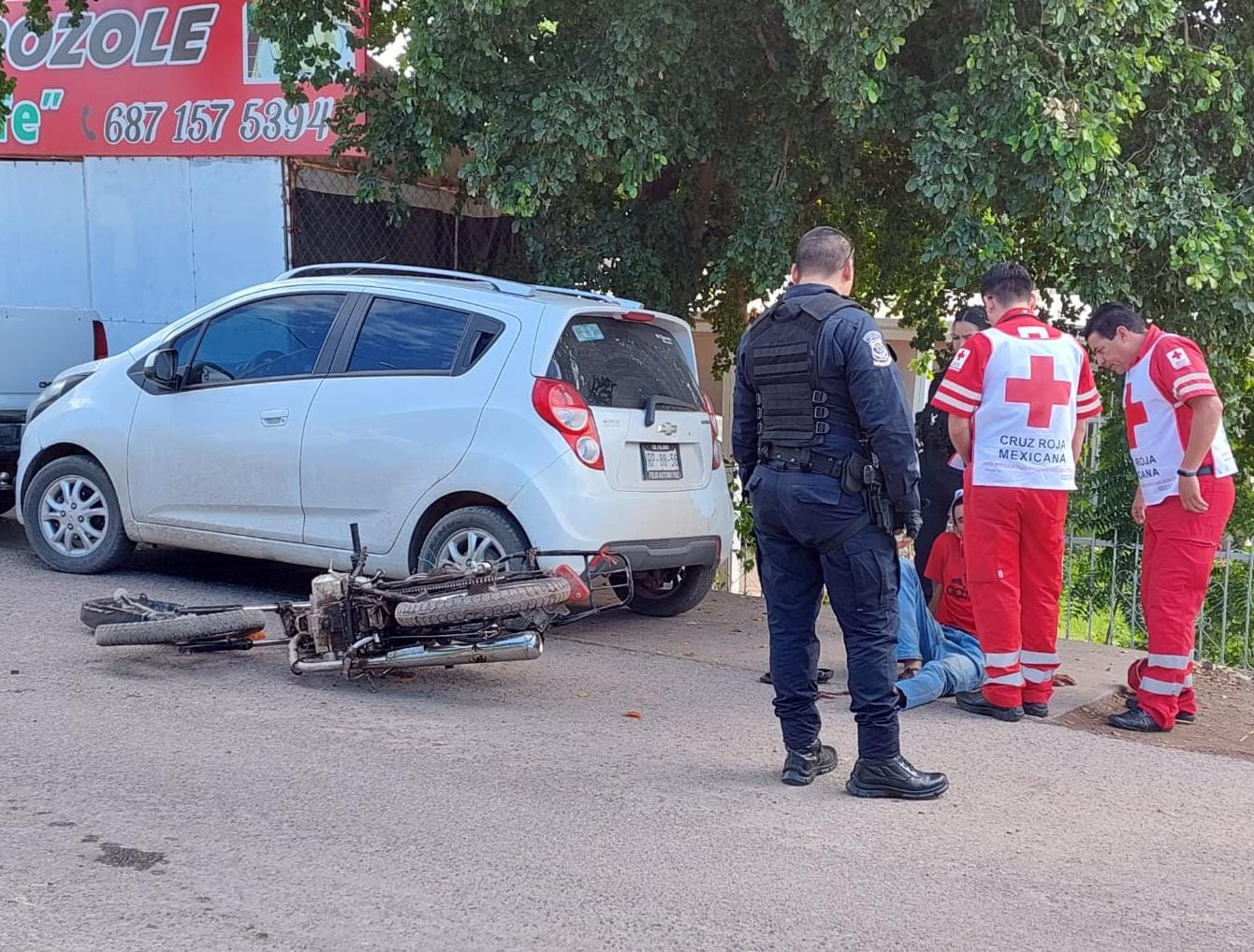 Policía y paramédicos detrás del auto donde chocó la moticicleta conducida por Alberto