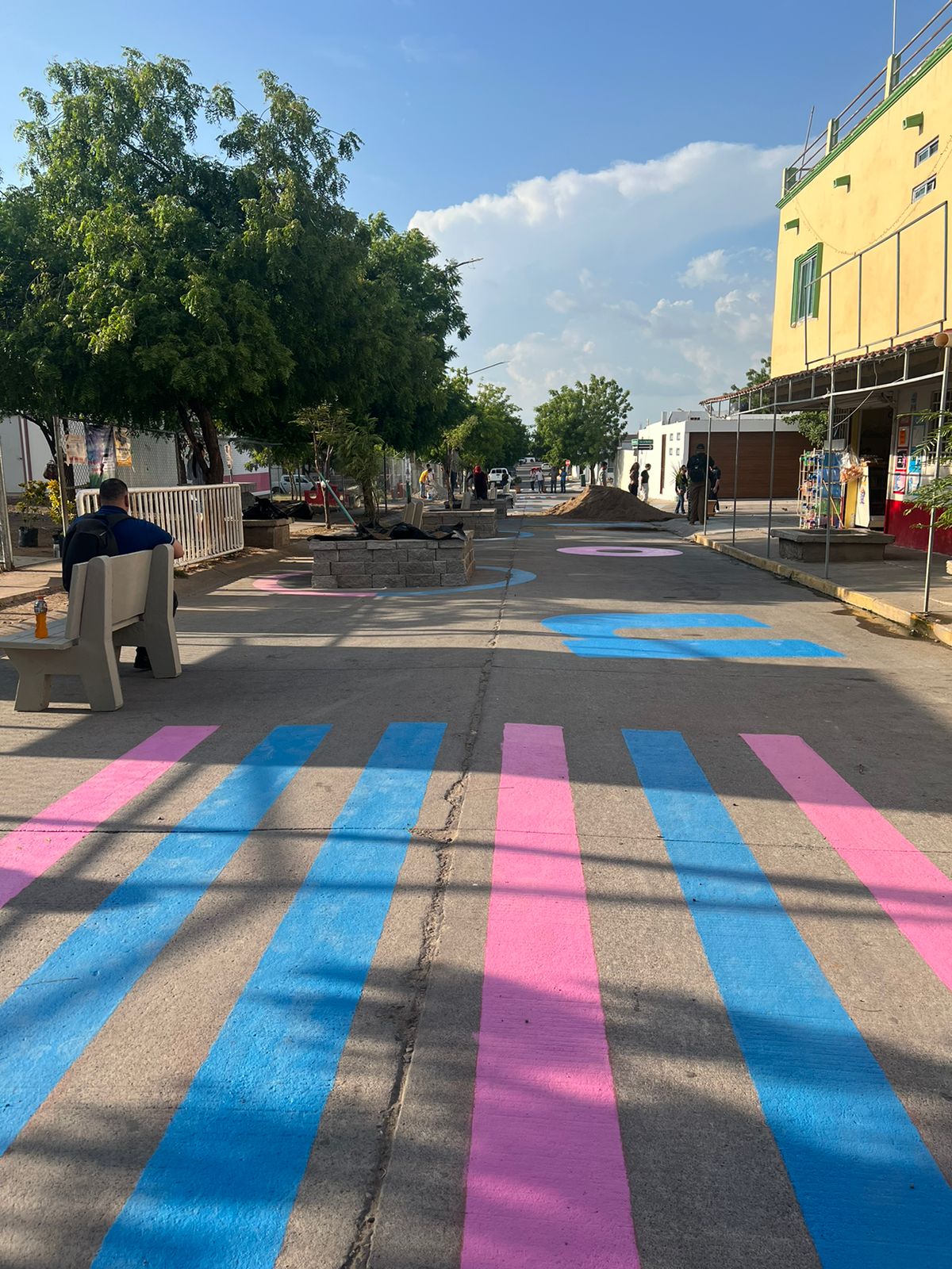 Pase peatonal pintado de color azul con rosa
