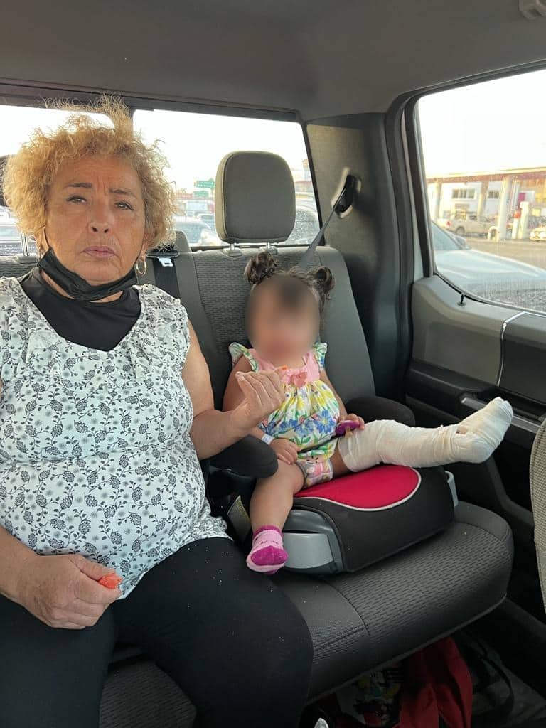 Una señora y una niña sentadas en la parte trasera de un carro