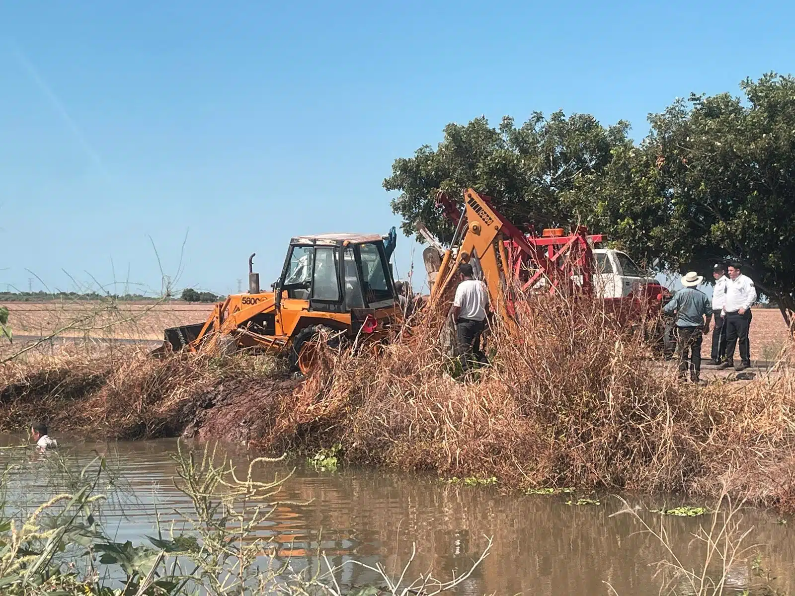 Retroexcavadora en la orilla de un canal