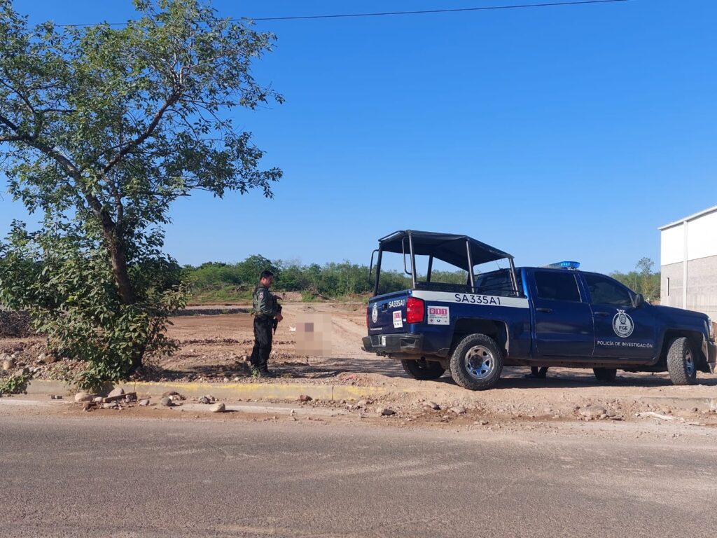 Un agente de la Fiscalía resguarda la escena afuera de la patrulla