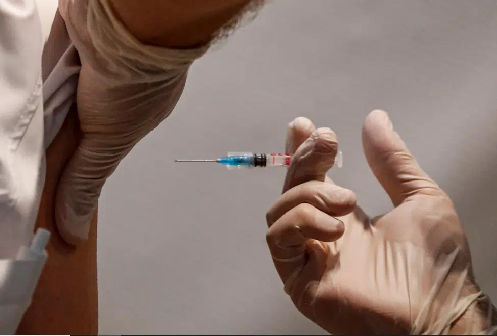Persona aplicando una vacuna en el brazo